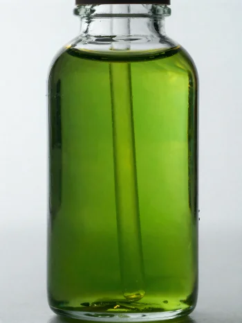 밝은 배경에 놓인 작은 병과 그릇에 담긴 아보카도 오일